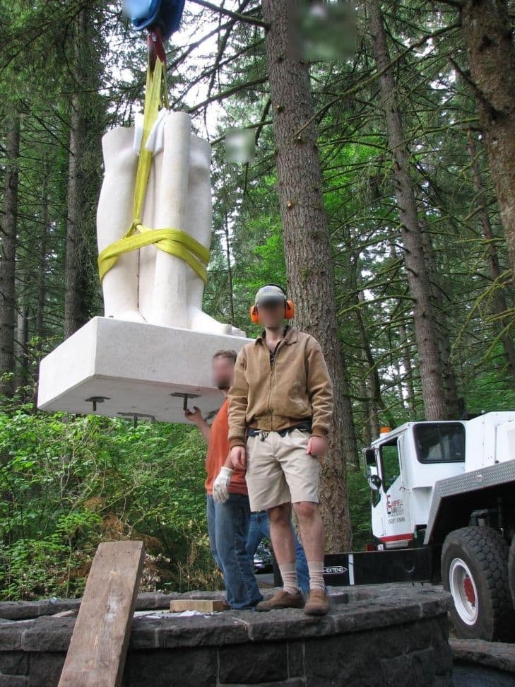 Workers guiding statue feet